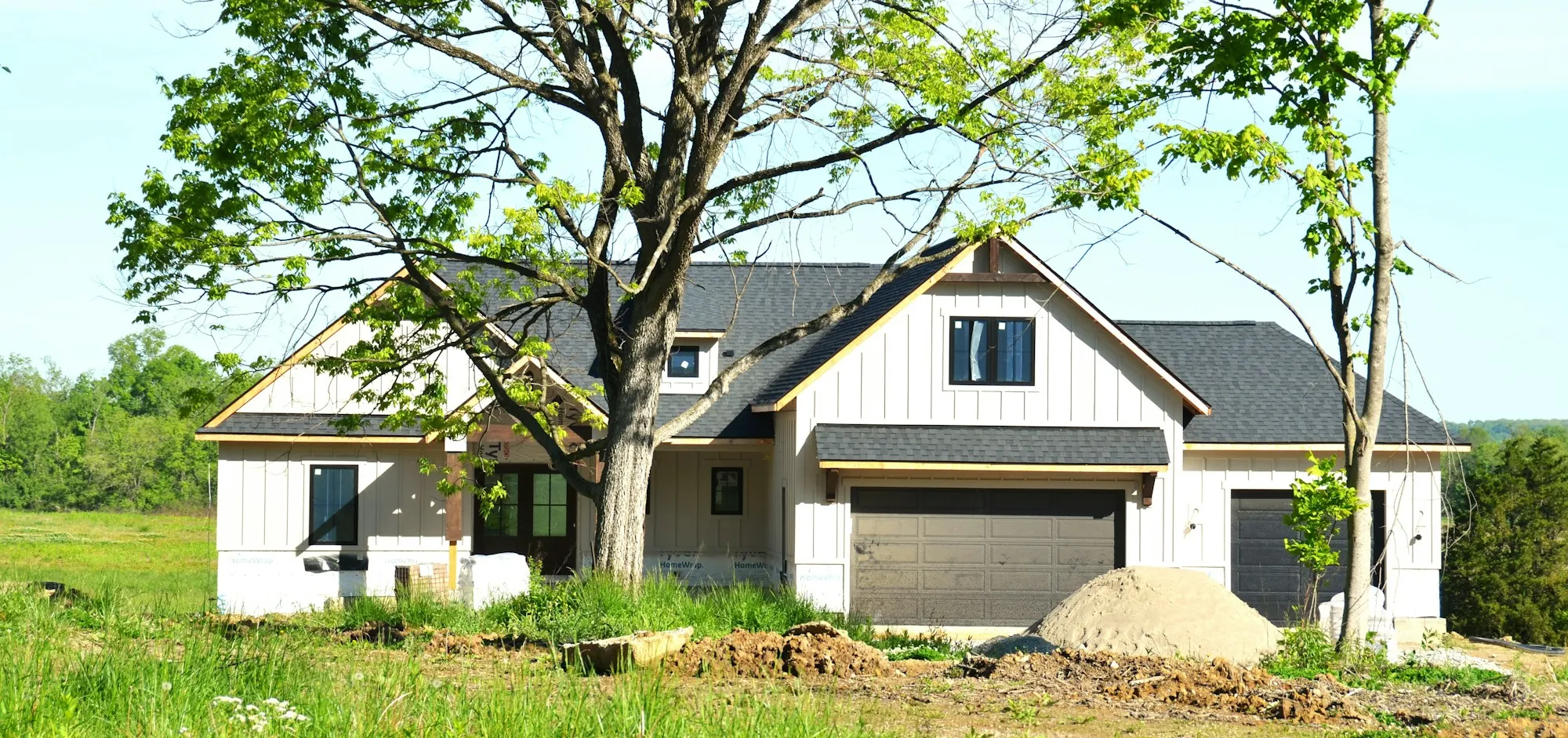 Modern farmhouse with a dark shingle roof and board-and-batten siding