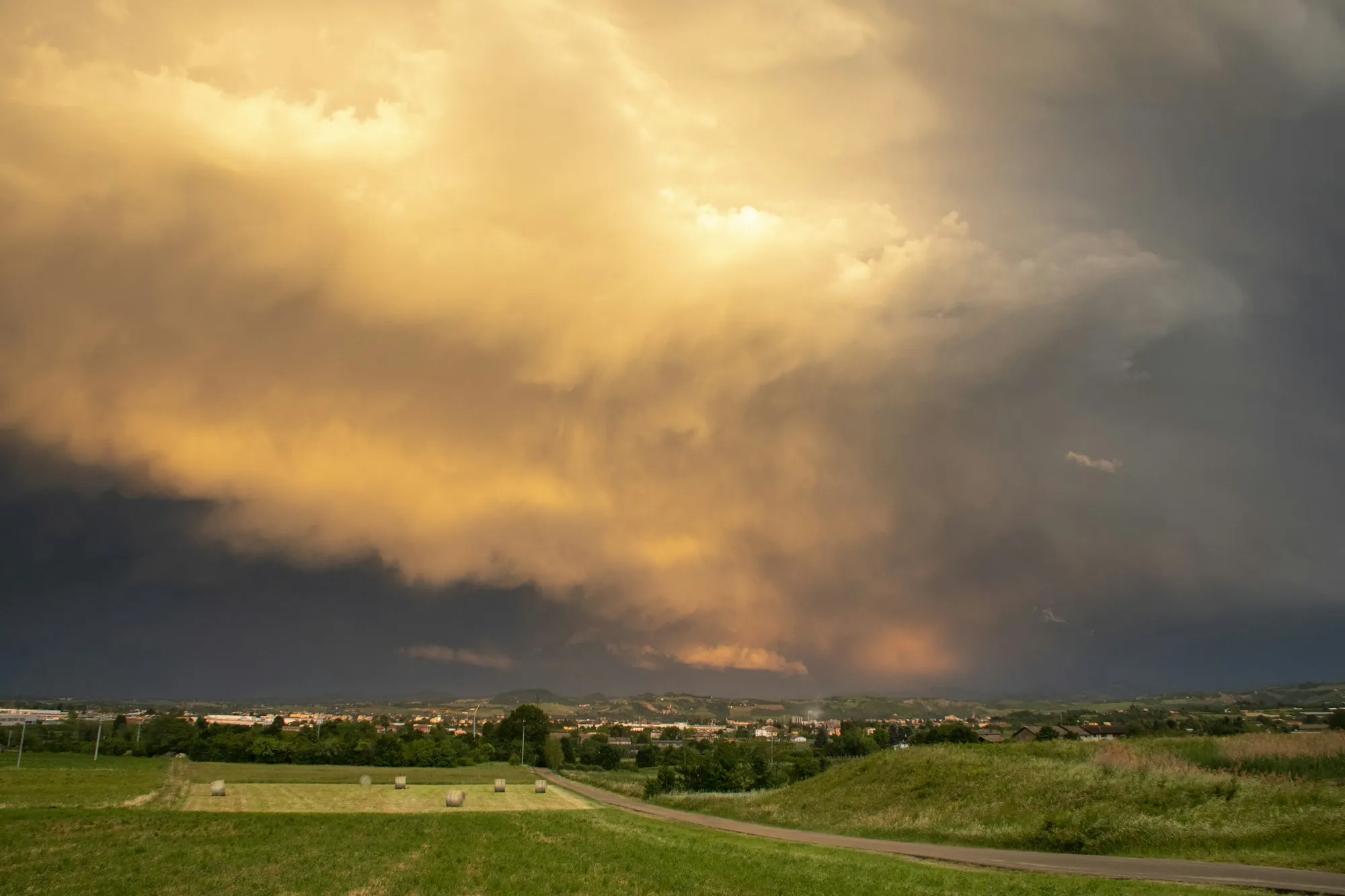 Golden storm light over open fields before a thunderstorm